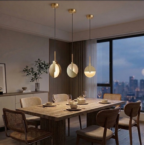 Solaris gold mid century pendant light in matt gold installed above a modern dining table