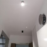 Black surface mount cylinder downlight installed on white BTO foyer ceiling