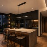 Minimalist black hanging linear light with remote suspended above a stone kitchen island in a Singapore condo with mid-century modern interior design.
