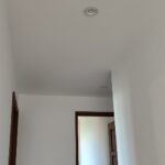 White eyeball recessed downlights installed along a home hallway ceiling