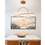 Triple Gold ring pendant light installed above modern dining table