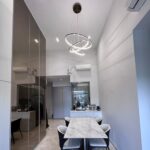 Rose gold triple ring pendant light installed above a marble dining table