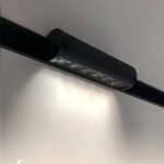 Tiltable magnetic grille track light directing light onto wall