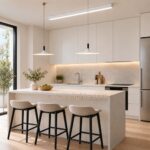 Two minimalist white disc pendant lights above a modern kitchen island